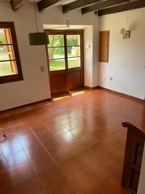 an empty room with a tiled floor and a door at Casa rural El Bruguer Vell in Santa Eulalia de Ronsaná