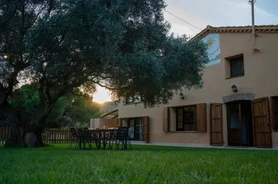 a house with a table and chairs in the yard at Casa rural El Bruguer Vell in Santa Eulalia de Ronsaná