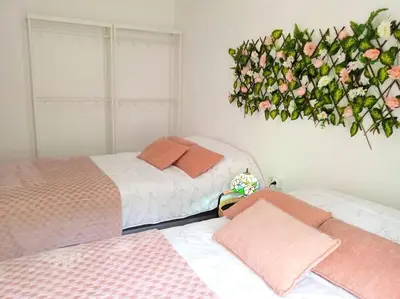 two beds in a room with a flower arrangement on the wall at GARDEN'S SEA PiNEDA DE MAR in Pineda de Mar