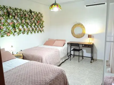 a bedroom with two beds and a desk with a mirror at GARDEN'S SEA PiNEDA DE MAR in Pineda de Mar