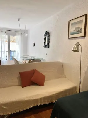 a living room with a couch with two pillows on it at Migjorn Apartment a place in the heart of Sitges in Sitges