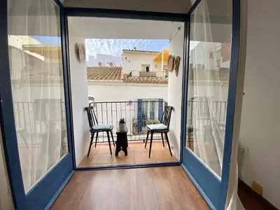 two chairs sitting on the balcony of a house at Migjorn Apartment a place in the heart of Sitges in Sitges