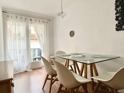a dining room with a glass table and chairs at Migjorn Apartment a place in the heart of Sitges in Sitges