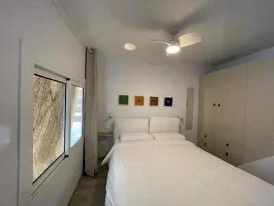 a bedroom with a white bed and a window at Baetulo III in Badalona