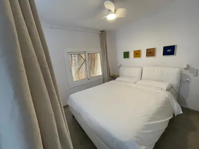 a white bed in a room with a window at Baetulo III in Badalona