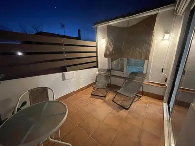 a balcony with chairs and a table and a window at Baetulo III in Badalona