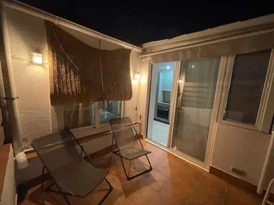 a balcony with two chairs and a table and a window at Baetulo III in Badalona