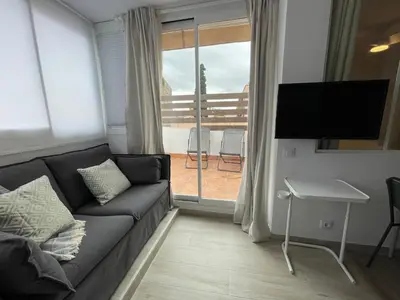 a living room with a couch and a large window at Baetulo III in Badalona