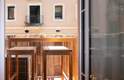 a balcony with two wooden stools on a balcony at Charming Seaside Apartment in Barceloneta, Renovated with Stunning Sea Views in Barcelona
