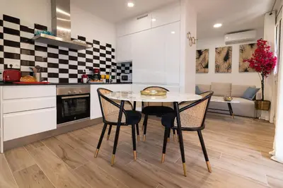a kitchen with a table and chairs in a room at Charming Seaside Apartment in Barceloneta, Renovated with Stunning Sea Views in Barcelona