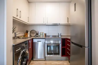 a kitchen with white cabinets and a stainless steel refrigerator at 42MAL1083 - Great 2Br near Sagrada Familia in Barcelona