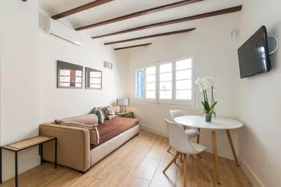 a living room with a bed and a table at Apartamentos Mayor by Habama Group in Sitges