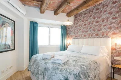 a bedroom with a large bed with blue curtains at Apartamentos Mayor by Habama Group in Sitges