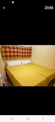 a yellow bed with a plaid headboard in a room at Apartment in Downtown 2 bedrooms AC 30 nigths min in Barcelona