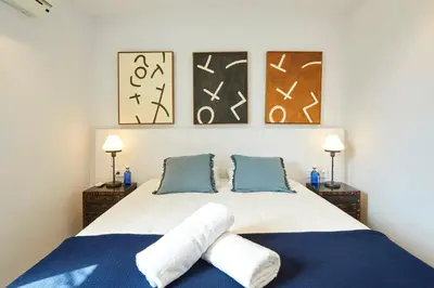a bedroom with a bed and three paintings on the wall at 