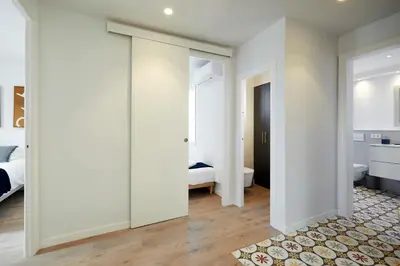 a bedroom with white walls and a sliding door at 