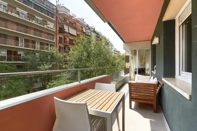 a balcony with a table and chairs and a building at 