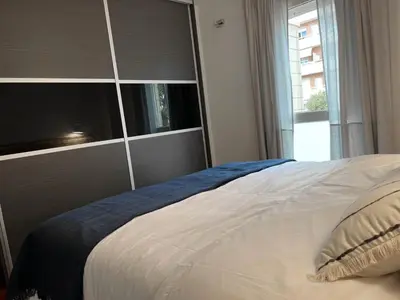 a bedroom with a large bed with a large window at Opening Doors Premiá Beach - Sol & playa cerca Barcelona in Premiá de Mar