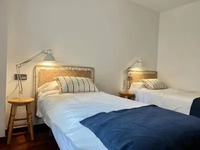 a bedroom with two beds and a lamp on the wall at Opening Doors Premiá Beach - Sol & playa cerca Barcelona in Premiá de Mar