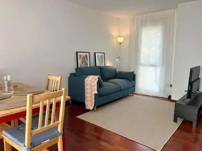 a living room with a blue couch and a table at Opening Doors Premiá Beach - Sol & playa cerca Barcelona in Premiá de Mar