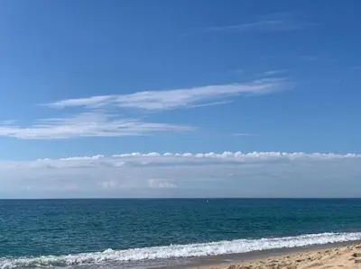 a beach with the ocean and a blue sky and clouds at Penthouse 100m from Sea with Terrace, Near BCN in Mataró