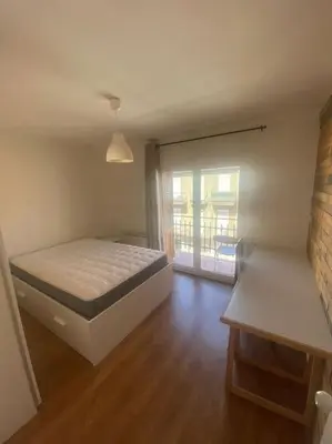 a bedroom with a bed and a sliding glass door at HABITACIÓN DOBLE, near train, bus that goes to Barcelona in Manresa