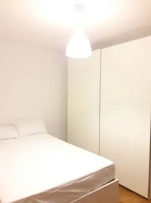 a white room with a bed and a light at HABITACIÓN DOBLE, near train, bus that goes to Barcelona in Manresa