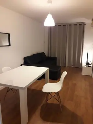 a living room with a white table and a couch at HABITACIÓN DOBLE, near train, bus that goes to Barcelona in Manresa
