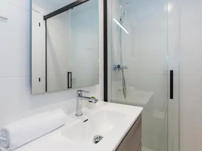 a white bathroom with a sink and a shower at Sitges Spaces Seaside Paradise in Sitges