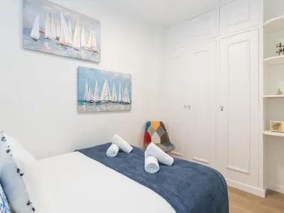 a white bedroom with a bed with sails on the wall at Sitges Spaces Seaside Paradise in Sitges