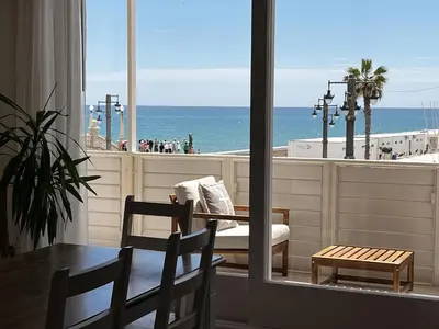 a room with a table and chairs and a view of the beach at Sitges Spaces Seaside Paradise in Sitges