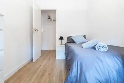 a bedroom with a bed with blue pillows on it at Apartamento Granollers in Granollers