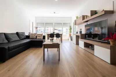 a living room with a black couch and a table at Apartamento Granollers in Granollers