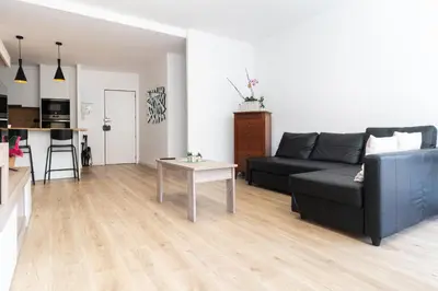 a living room with a black couch and a table at Apartamento Granollers in Granollers