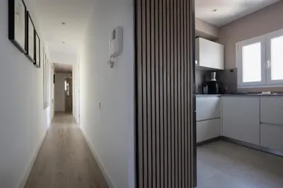 a kitchen with white walls and a long hallway at Fantastic view penthouse apartment in Barcelona