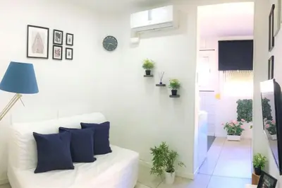 a white living room with a white couch with blue pillows at Best refuge in Barcelona in Sant Adria de Besos