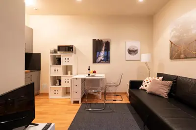 a living room with a couch and a bridge painting on the wall at 2762 - AB Park Guell Apartment B-II in Barcelona
