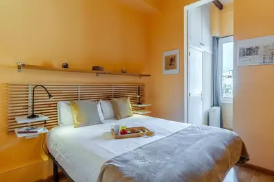 a bedroom with a large bed with yellow walls at 4179 - AB Verdi Villa de Gracia Apartment in Barcelona