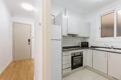a kitchen with white cabinets and a white refrigerator at 4254 - AB Sagrada Familia Views III-II in Barcelona