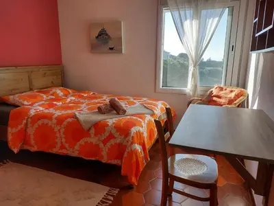 a bedroom with a bed and a table and a window at Can Loïs in Sant Cebrià de Vallalta