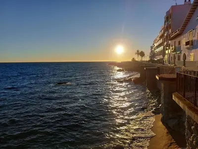 a view of the ocean with the sun setting over the water at Can Loïs in Sant Cebrià de Vallalta
