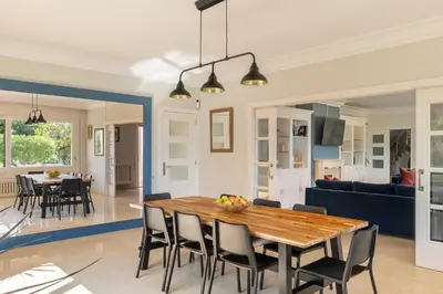 a dining room and living room with a table and chairs at Sea View Villa with Spa & BBQ in Badalona