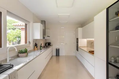 a kitchen with white counters and a large window at Sea View Villa with Spa & BBQ in Badalona