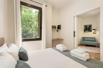 a bedroom with a white bed and a window at Enjoy Apartments La Riera Principal in Barcelona