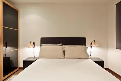 a bedroom with a large white bed with two lamps at Enjoy Apartments Urban Retreat Valencia 4 in Barcelona