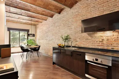 a kitchen with a brick wall and a table at Enjoy Apartments Urban Retreat Valencia 4 in Barcelona