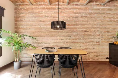 a dining room with a brick wall and a table and chairs at Enjoy Apartments Urban Retreat Valencia 4 in Barcelona