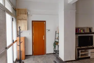 a hallway with a wooden door and a television at Full 50sqm Loft in Badalona in Badalona