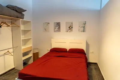 a bedroom with a bed with red sheets at Full 50sqm Loft in Badalona in Badalona