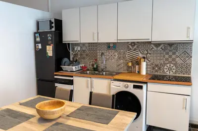 a kitchen with white cabinets and a table with a dishwasher at Full 50sqm Loft in Badalona in Badalona